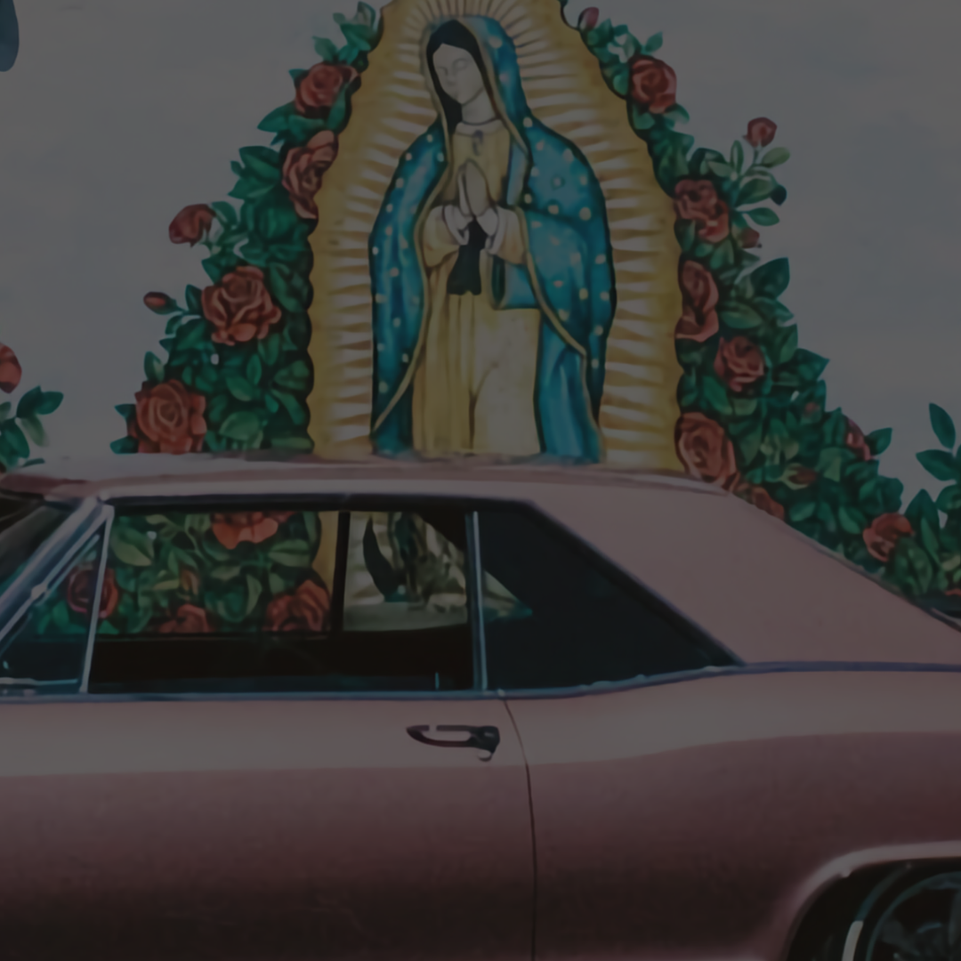 Pink car with the windows down and a mural of la Virgin de Guadalupe surrounded by red roses