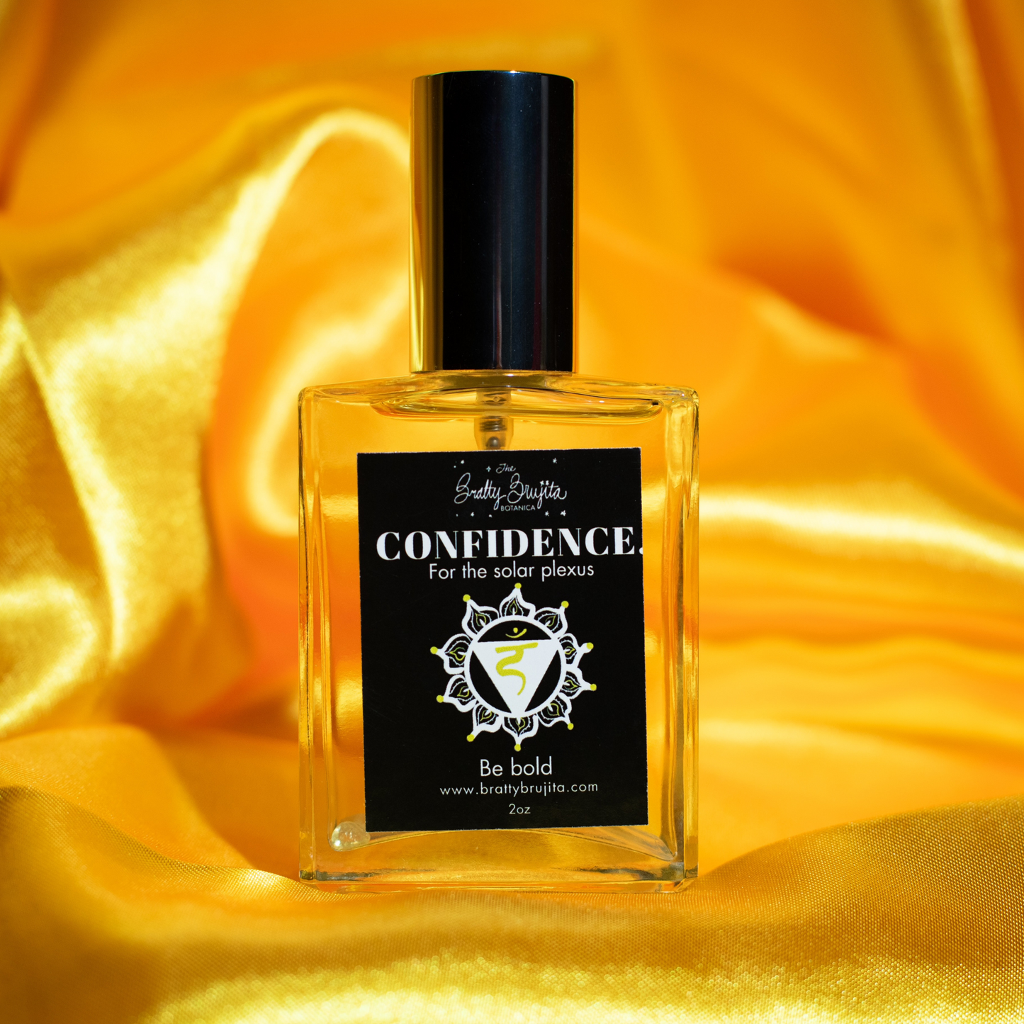 A glass bottle with a silver cap of 'Confidence' aura spray with a black label and yellow background.