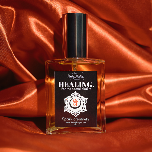 An orange back drop with a square glass bottle with a silver cap and black label and white writing