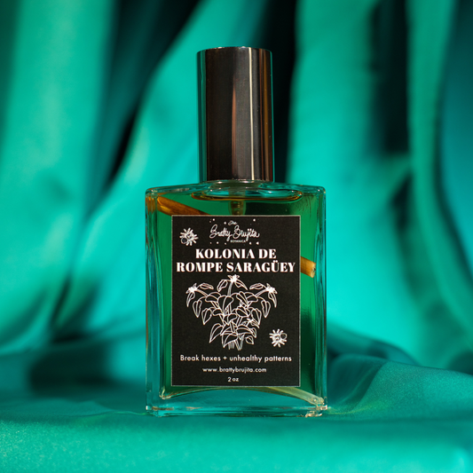 A green background with a square glass bottle with a silver cap and a black label and white writing